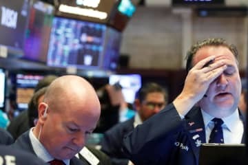 ニューヨーク証券取引所のトレーダー＝18日（ロイター＝共同）
